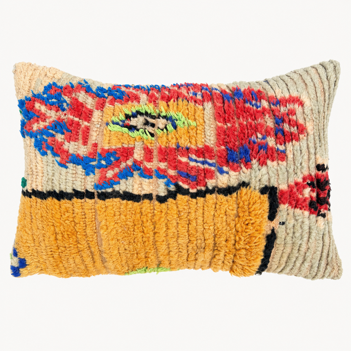 A rectangular handwoven throw pillow with a textured, shaggy surface. The design features a bold abstract pattern in red, blue, yellow, green, and black on a cream-colored base, with a prominent mustard yellow band across the lower half.