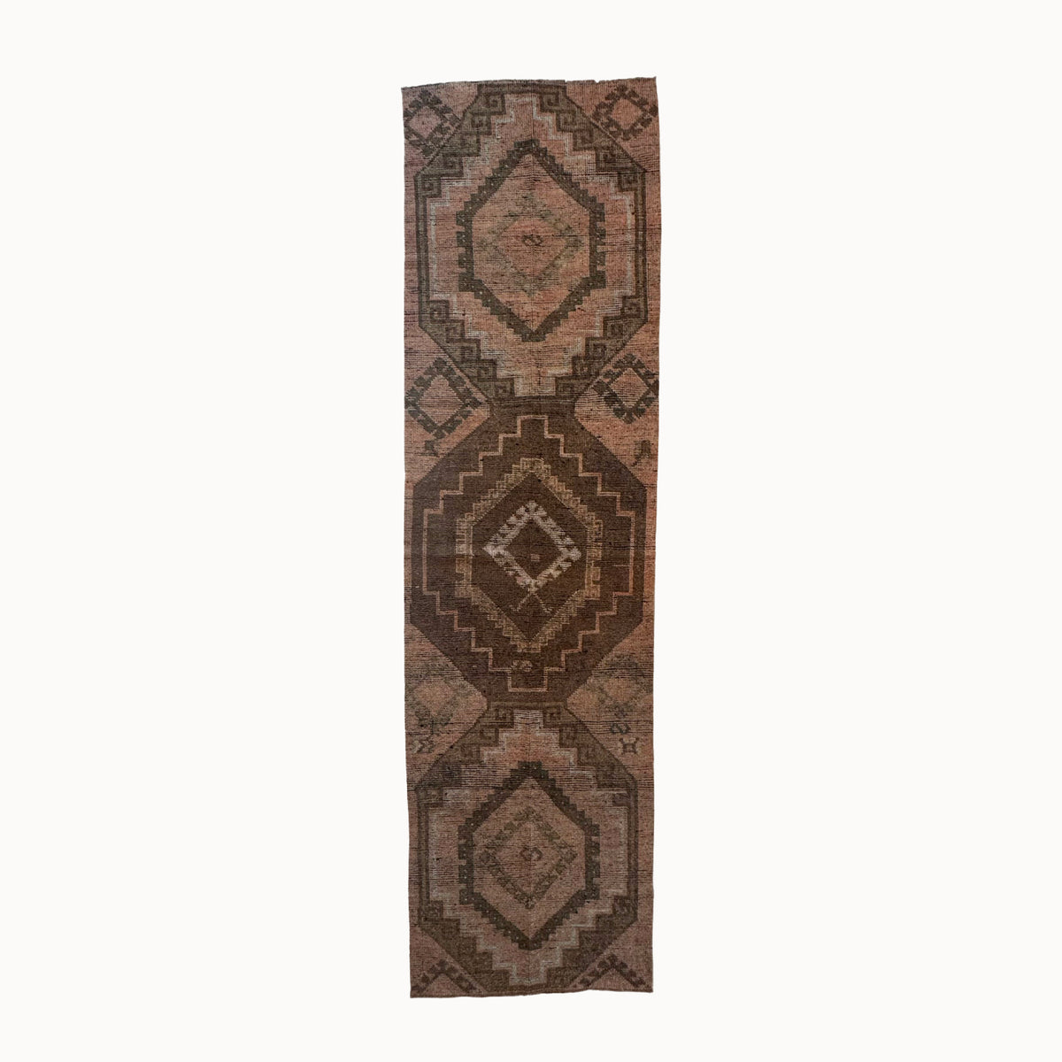 Long rectangular brown rug with geometric pattern on a white background