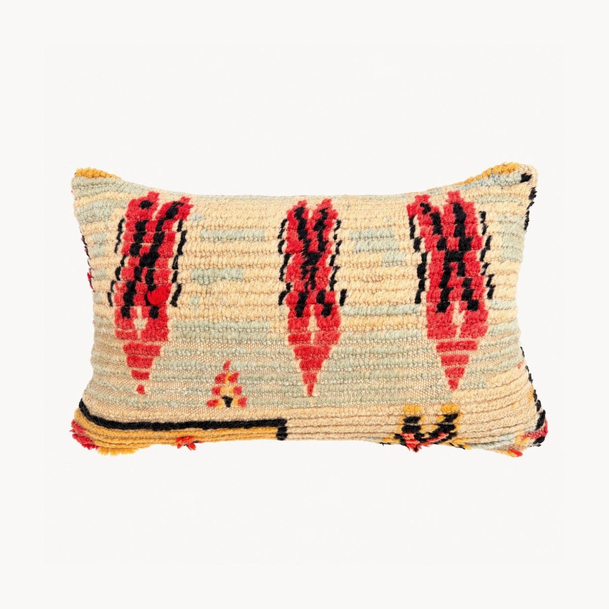 A rectangular woven throw pillow with a cream base and a bold geometric pattern in red, black, and yellow, shown against a plain white background.
